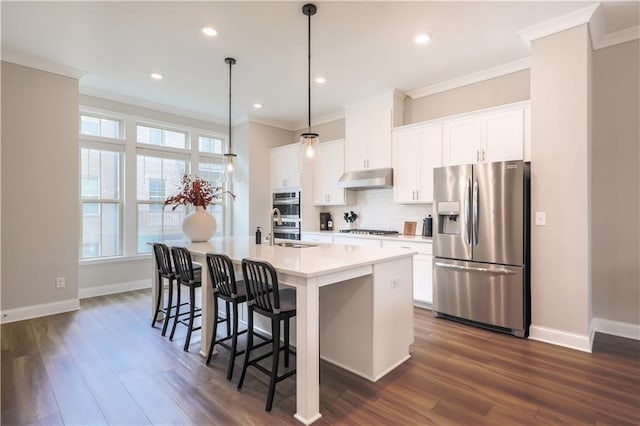 kitchen with gas cooktop, under cabinet range hood, a sink, stainless steel refrigerator with ice dispenser, and an island with sink