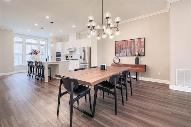 dining room with ornamental molding, dark wood-style flooring, visible vents, and baseboards