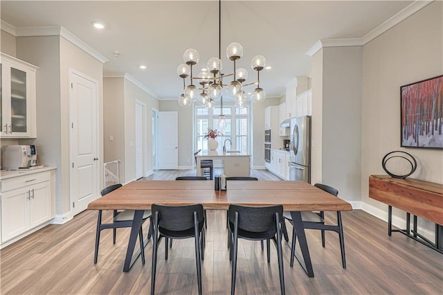 dining space with light wood-style flooring, baseboards, crown molding, and recessed lighting