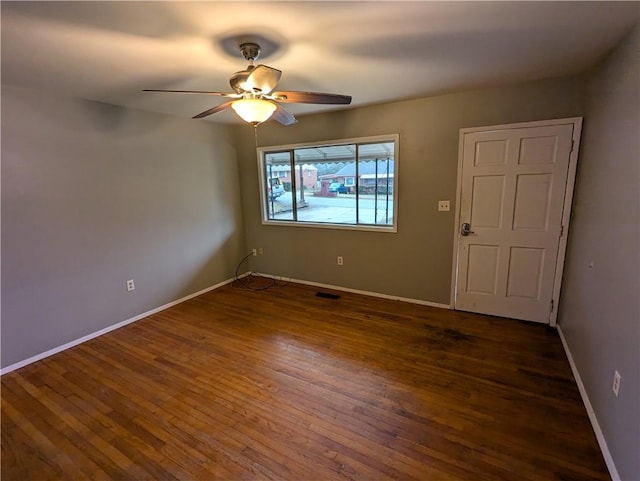 empty room featuring dark wood-type flooring and ceiling fan