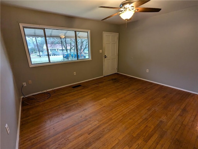 empty room with ceiling fan and dark hardwood / wood-style flooring