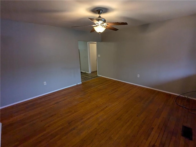 spare room with dark hardwood / wood-style floors and ceiling fan