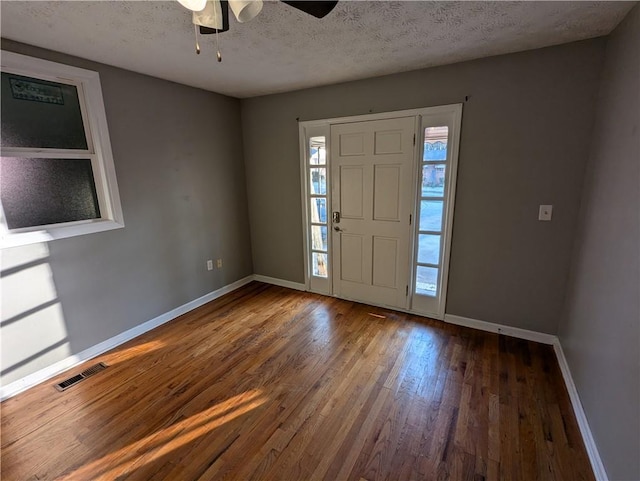 entryway with ceiling fan, dark hardwood / wood-style floors, and a textured ceiling