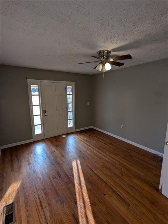 entryway featuring ceiling fan, a textured ceiling, and dark hardwood / wood-style flooring