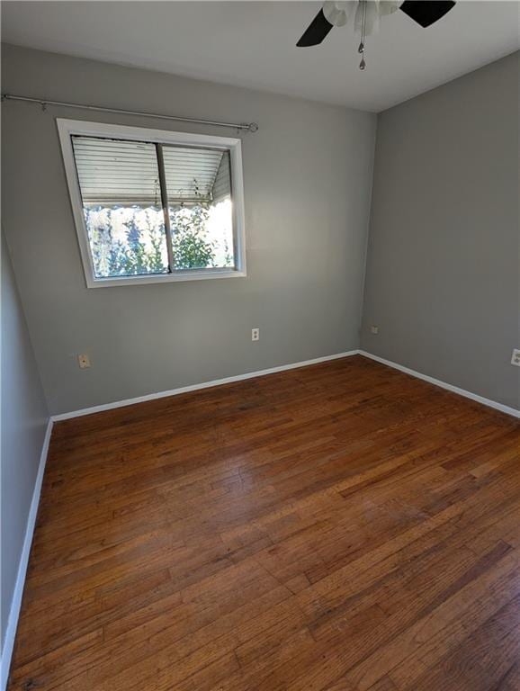 spare room with dark wood-type flooring and ceiling fan