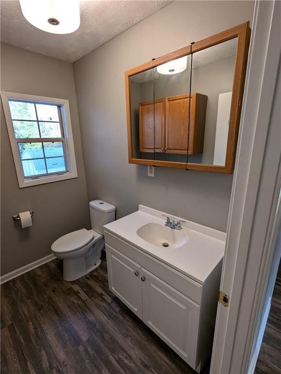 bathroom featuring vanity, hardwood / wood-style floors, toilet, and a textured ceiling