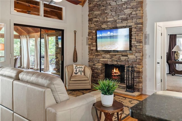 7875 Robin Rd, Cumming, GA 30041 - living area featuring a stone fireplace, a ceiling fan, lofted ceiling, and wood finished floors