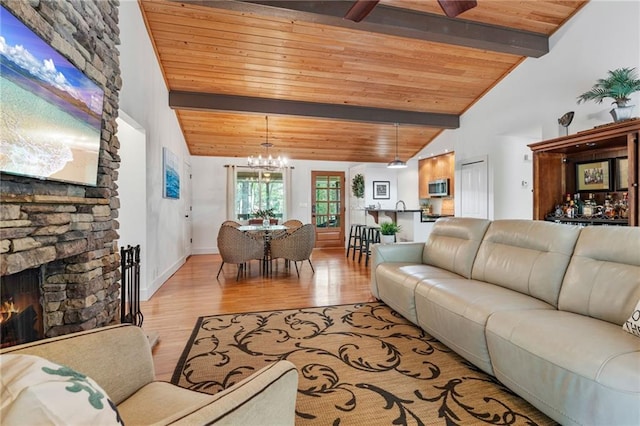 7875 Robin Rd, Cumming, GA 30041 - living area featuring wooden ceiling, a chandelier, light wood finished floors, a stone fireplace, and baseboards