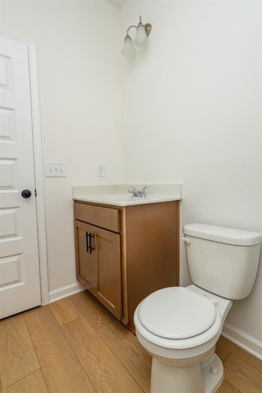 296 River Run Dr, Dallas, GA 30132 - half bathroom featuring vanity, wood finished floors, toilet, and baseboards