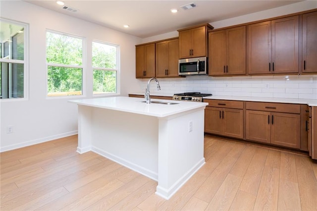 296 River Run Dr, Dallas, GA 30132 - kitchen with a sink, stainless steel microwave, brown cabinets, decorative backsplash, and light countertops
