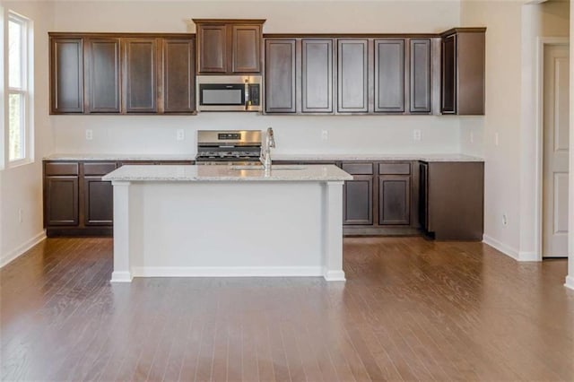 296 River Run Dr, Dallas, GA 30132 - kitchen featuring appliances with stainless steel finishes, a sink, dark wood-style flooring, a kitchen island with sink, and baseboards