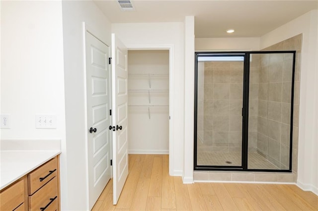 296 River Run Dr, Dallas, GA 30132 - full bathroom with a shower stall, wood finished floors, vanity, a walk in closet, and baseboards