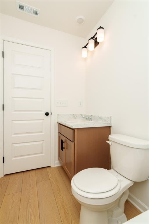 296 River Run Dr, Dallas, GA 30132 - bathroom with wood finished floors, vanity, baseboards, and toilet