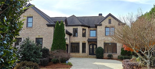 view of front facade with brick siding and a chimney