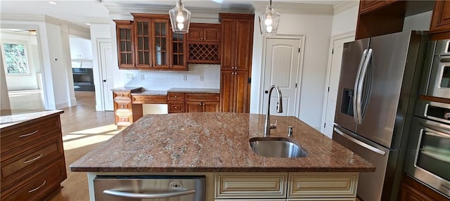 kitchen with tasteful backsplash, glass insert cabinets, ornamental molding, appliances with stainless steel finishes, and a sink