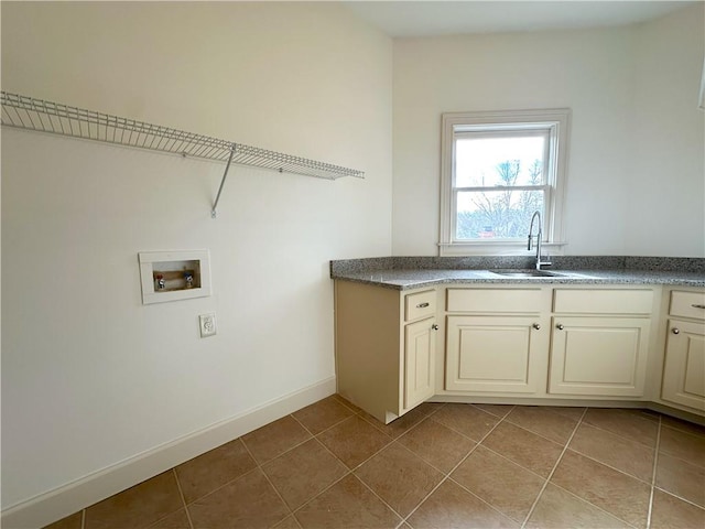 clothes washing area with washer hookup, a sink, cabinet space, tile patterned flooring, and baseboards