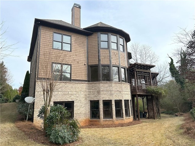 back of property featuring stairs, a yard, brick siding, and a chimney