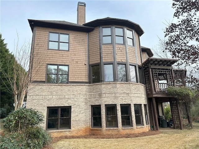 rear view of property with brick siding and a chimney