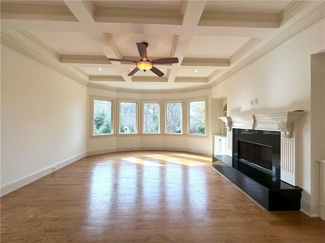 unfurnished living room with plenty of natural light, wood finished floors, and a high end fireplace