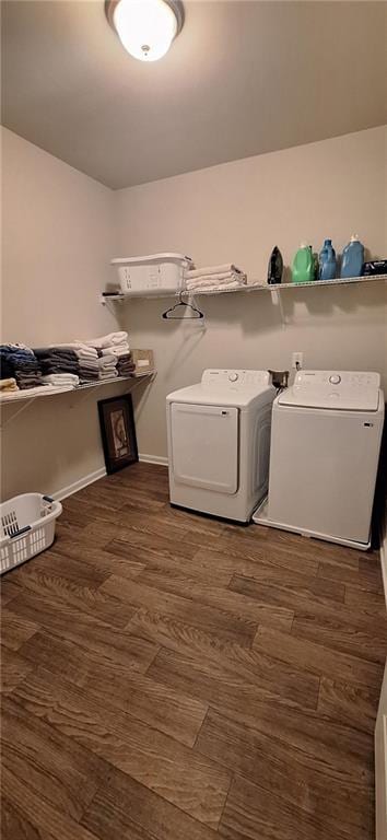 laundry area with dark hardwood / wood-style floors and washing machine and clothes dryer