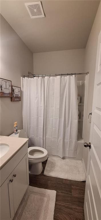 full bathroom featuring wood-type flooring, toilet, vanity, and shower / bath combo