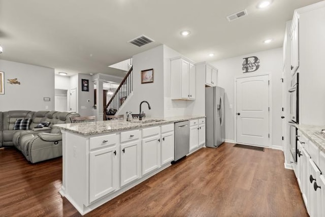 kitchen featuring white cabinetry, appliances with stainless steel finishes, sink, and light stone counters