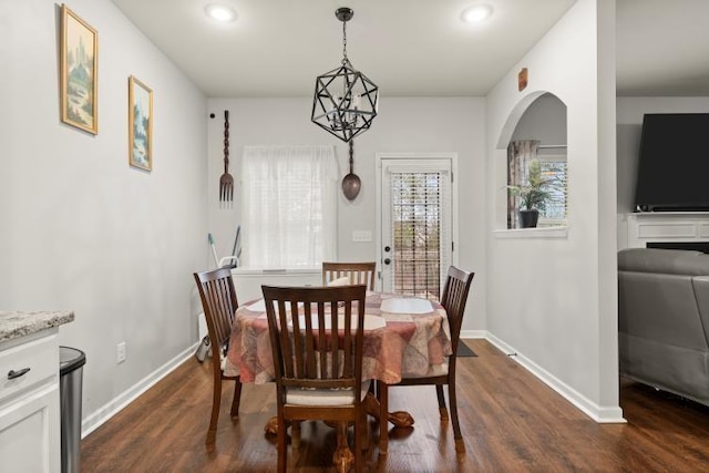 dining space with dark hardwood / wood-style floors and a chandelier