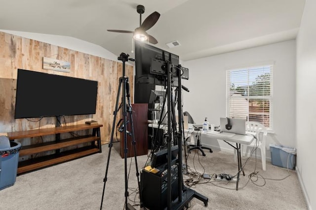 interior space featuring lofted ceiling, ceiling fan, and wood walls