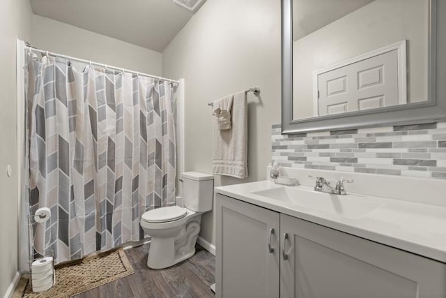 bathroom with hardwood / wood-style flooring, vanity, backsplash, and toilet