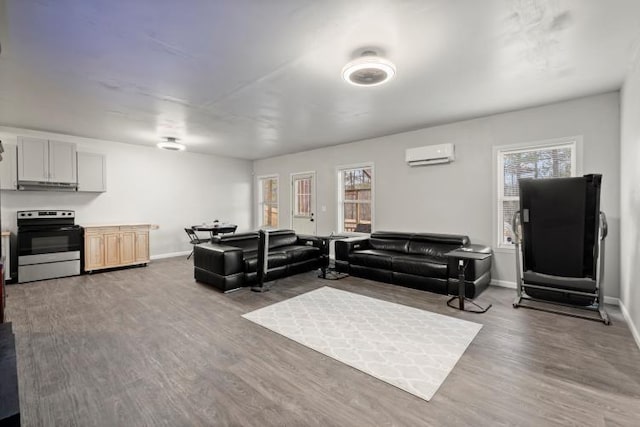 living room with hardwood / wood-style flooring and an AC wall unit