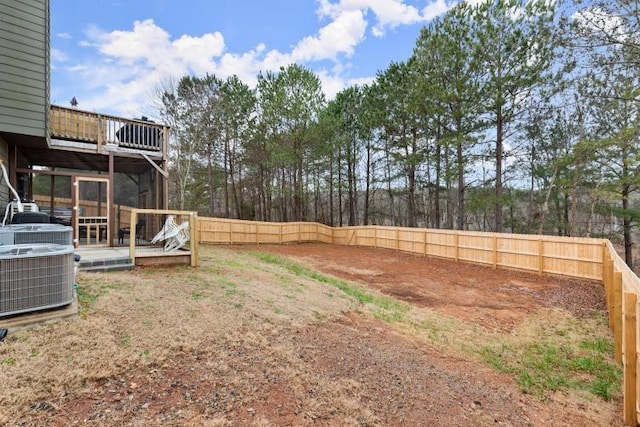 view of yard with central AC and a deck