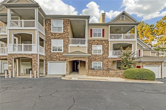 view of front of property featuring a balcony, central AC unit, and a garage