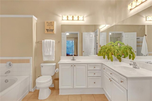 bathroom with tile patterned floors, a tub, vanity, and toilet