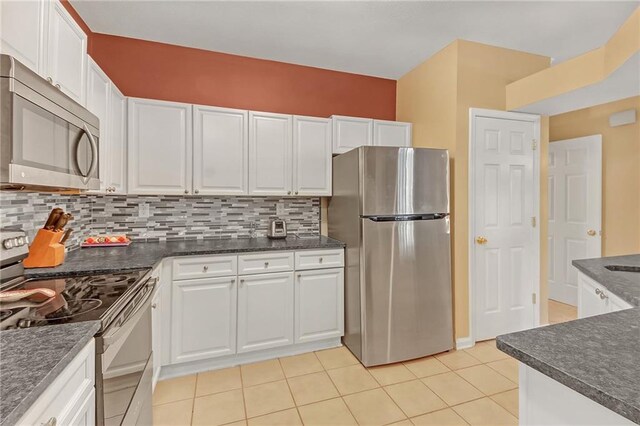 kitchen featuring backsplash, white cabinetry, light tile patterned floors, and stainless steel appliances