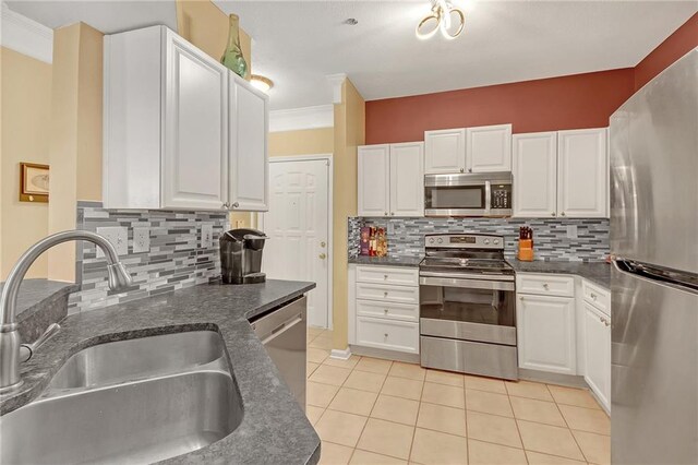 kitchen with sink, white cabinetry, appliances with stainless steel finishes, crown molding, and decorative backsplash