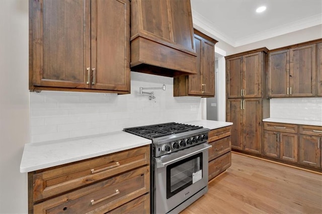 33 Cedar Gate Ln, Kingston, GA 30145 - kitchen with stainless steel range, tasteful backsplash, ornamental molding, premium range hood, and light wood-type flooring