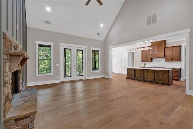 33 Cedar Gate Ln, Kingston, GA 30145 - unfurnished living room with high vaulted ceiling, light wood-style floors, a ceiling fan, a sink, and a fireplace