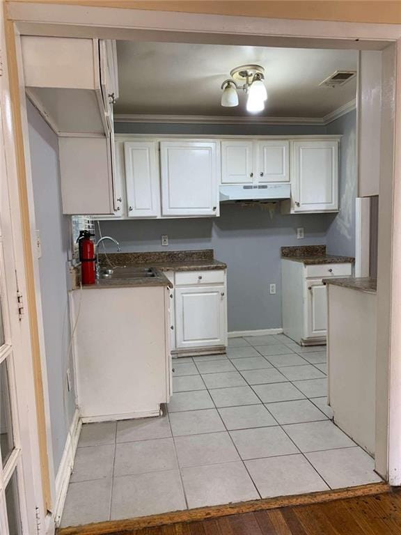 kitchen with crown molding, white cabinets, sink, and light wood-type flooring