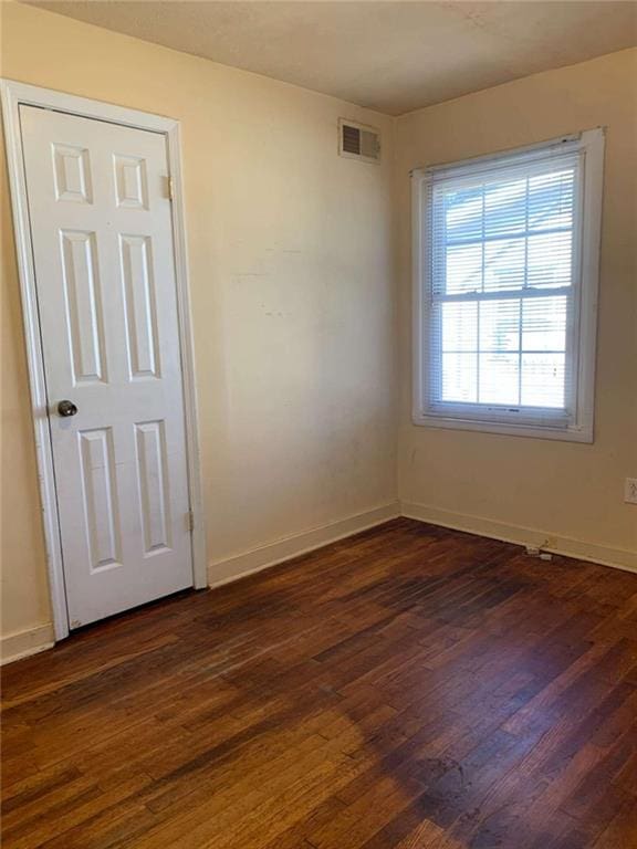 spare room with dark wood-type flooring