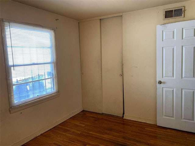 unfurnished bedroom featuring dark hardwood / wood-style flooring