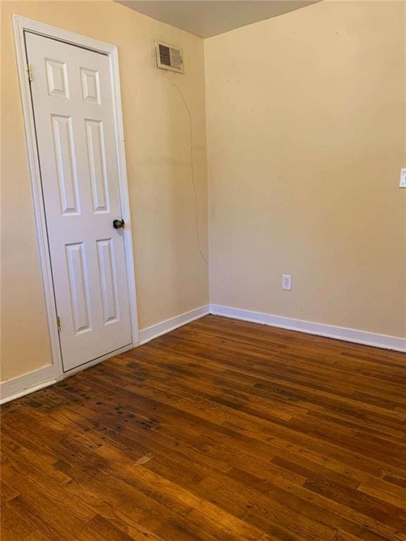 spare room featuring dark wood-type flooring