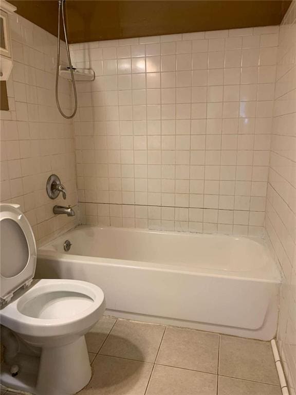 bathroom featuring toilet, tiled shower / bath, and tile patterned floors