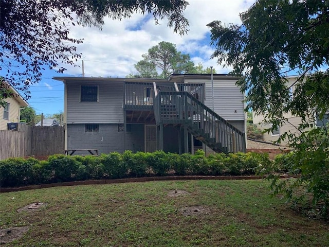 rear view of property featuring a deck and a lawn