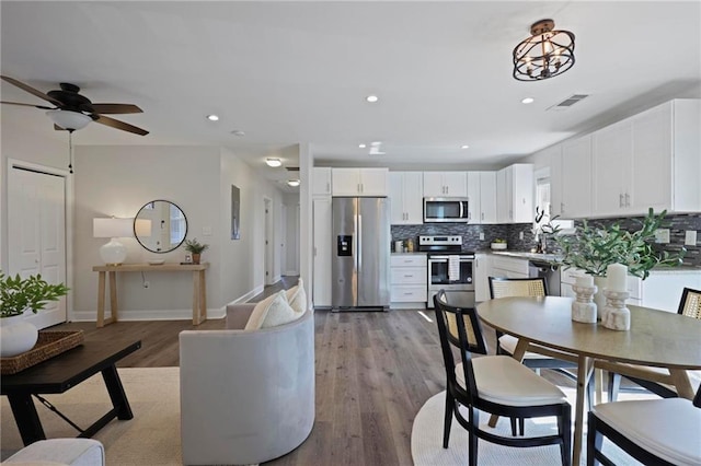 dining area with baseboards, light wood finished floors, visible vents, and recessed lighting