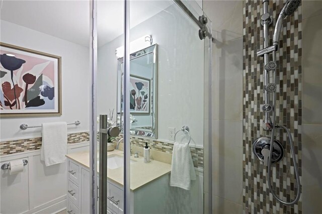 full bath featuring backsplash, a shower stall, and vanity