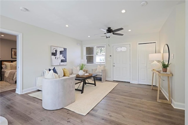 living room with baseboards, wood finished floors, a ceiling fan, and recessed lighting