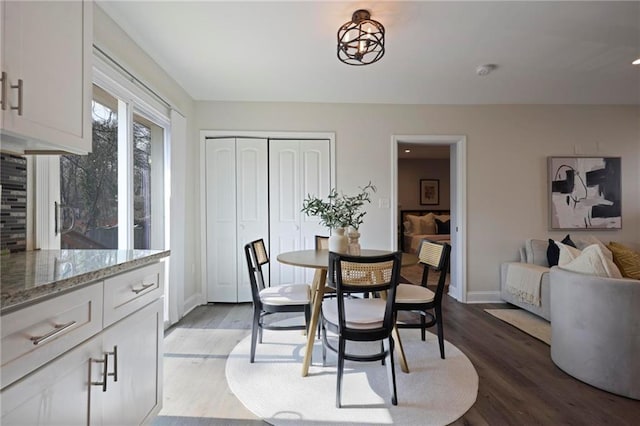 dining space with baseboards and wood finished floors