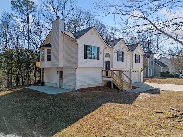 exterior space with a garage, a lawn, and a patio