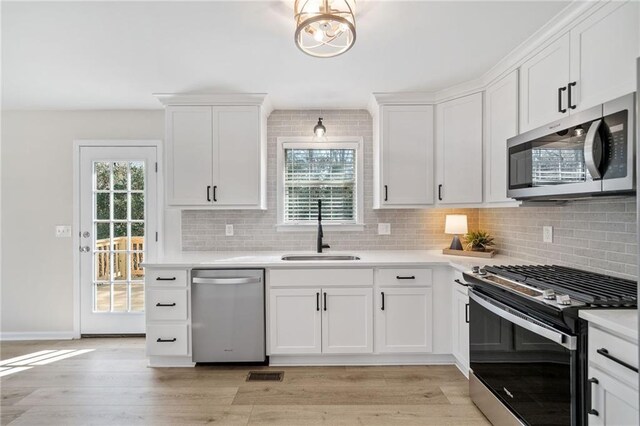 kitchen featuring appliances with stainless steel finishes, sink, and white cabinets