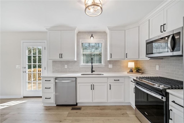 kitchen featuring stainless steel appliances, white cabinetry, and sink